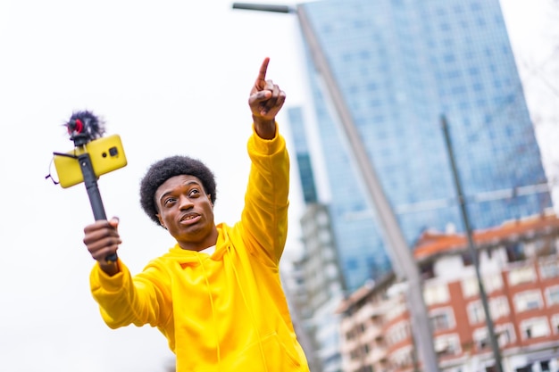 Photo vlogger pointing ahead during an online video in the city