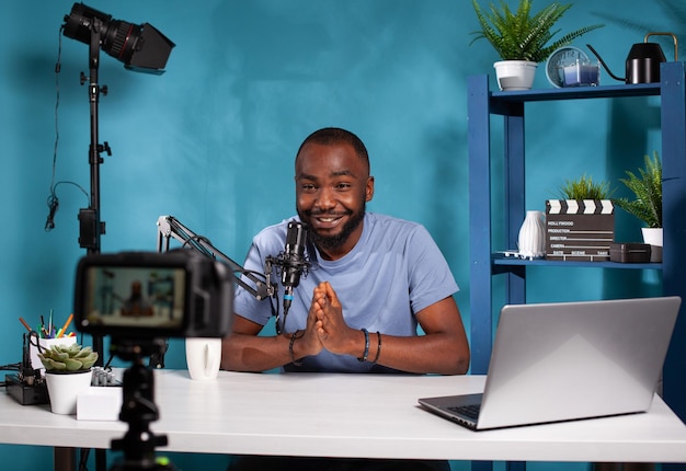 Vlogger saying thank you to audience in front of recording
digital video camera at the end of online live show. social media
content creator doing closing line finishing video podcast.