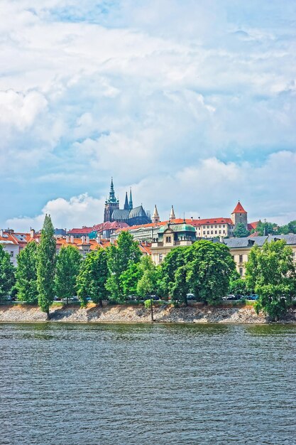 Vltava River embankment with Prague Old Town, Czech Republic. Strakova Academy with St Vitus Church on the background