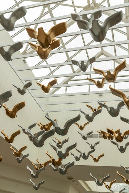 Vlucht bronzen vogels sculpturen op een winkelcentrum