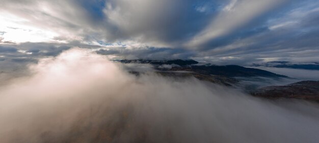 Foto vlucht door blauwe lucht met wolken over berg