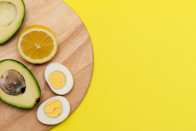 Аvocadoeggslemonnuts on the wooden cutting board