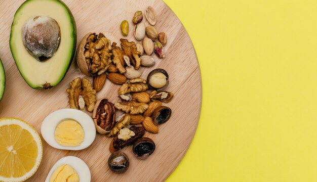 Аvocadoeggslemonnuts on the wooden cutting board