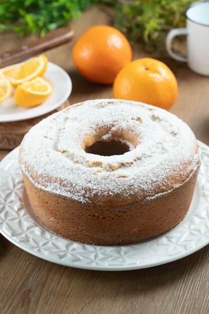 Vochtige sinaasappelfruitcake op bord met sinaasappelschijfjes op houten tafel Heerlijk ontbijt traditioneel Engels theetijd Recept voor sinaasappelcake