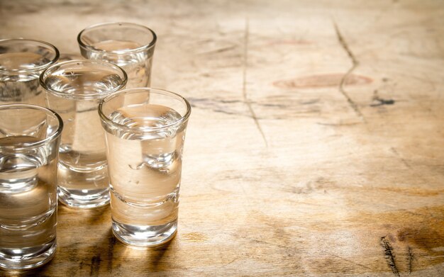 The vodka glass on a wooden background