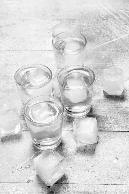 Photo vodka in a shot glass and ice cubes