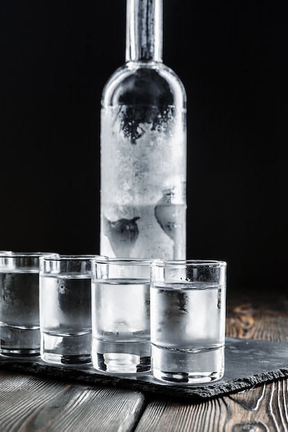 Photo vodka in shot glasses on rustic wood background