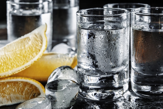 Vodka in shot glasses on rustic wood background