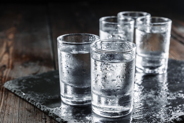 Foto vodka in bicchierini su legno rustico