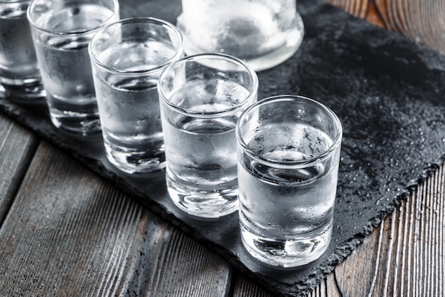 Photo vodka in shot glasses on rustic wood