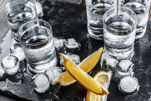 Vodka in shot glasses on rustic wood 