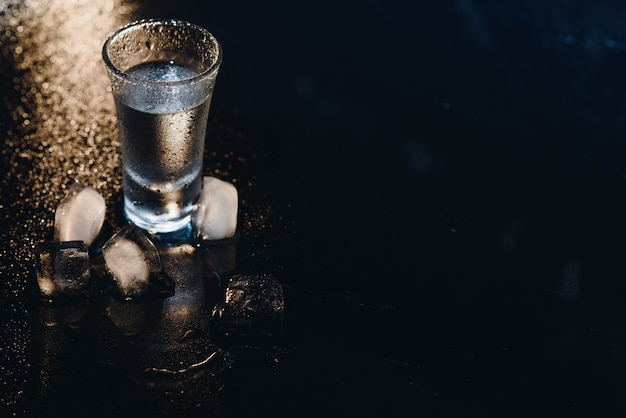 Vodka. Shots, glasses with vodka with ice .Dark background. Copy space .Selective focus