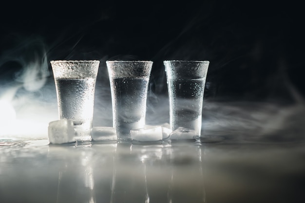 Vodka. Shots, glasses with vodka with ice .Dark background. Copy space .Selective focus