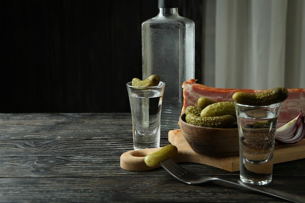 Vodka and tasty snacks on wooden table