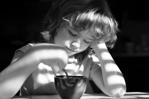 Voeding en gezonde eetgewoonten voor kinderen Thuis eten Jongen eet ontbijt in de keuken