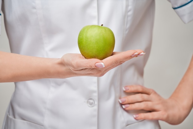 Voedingsdeskundige arts gezonde levensstijl concept - biologische verse groene appel te houden.