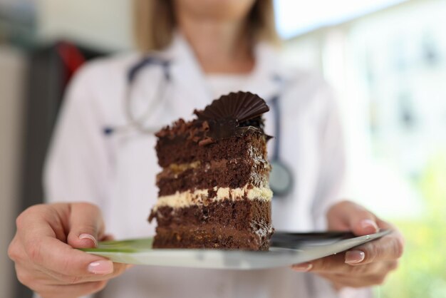 Voedingsdeskundige houdt een bord chocoladetaart in haar handen en waarschuwt tegen eten