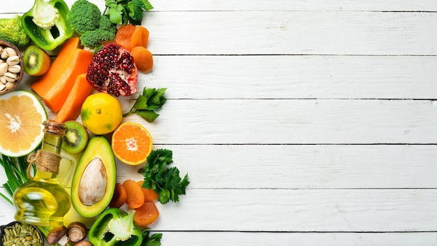 Voedsel achtergrond fruit groenten en bessen op een witte houten achtergrond Bovenaanzicht rustieke stijl