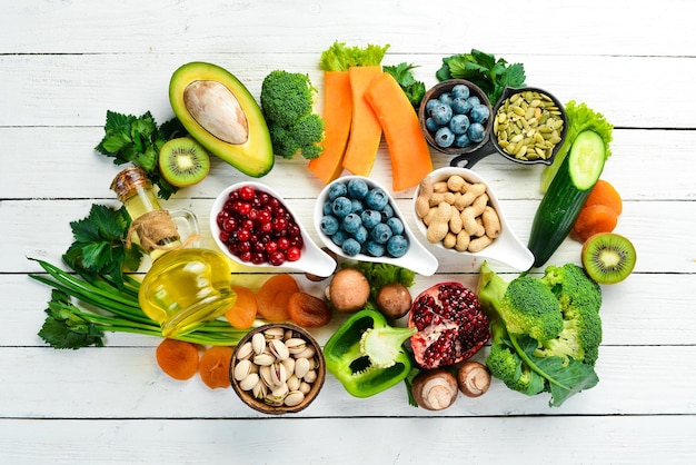 Voedsel achtergrond fruit groenten en bessen op een witte houten achtergrond Bovenaanzicht rustieke stijl