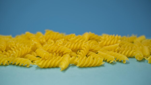 Voedsel achtergrond. Pasta fusilli op blauwe achtergrond. Kleurrijke achtergrond. Voedsel en dieet concept. vooraanzicht