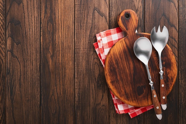 Voedsel achtergrond Zout peper rozemarijn tak houten standaard salade vork en lepel rode servet op houten koken achtergrond Voedsel koken achtergrond Ingrediënten voor het koken van voedsel achtergrond Mock up