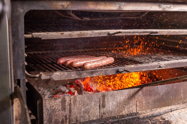 Voedsel, ambacht en heerlijk concept - kookworsten op een grill.