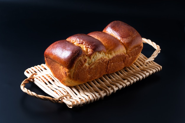 Voedsel bakken concept vers gebakken biologische zelfgemaakte zachte melk brood brood in brood pan op rieten brood lade