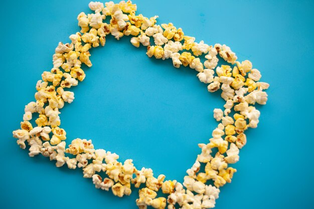 Voedsel bevroren popcorn maïs heerlijke gele popcorn op blauwe achtergrond Cinema Copyspace plaats voor tekst