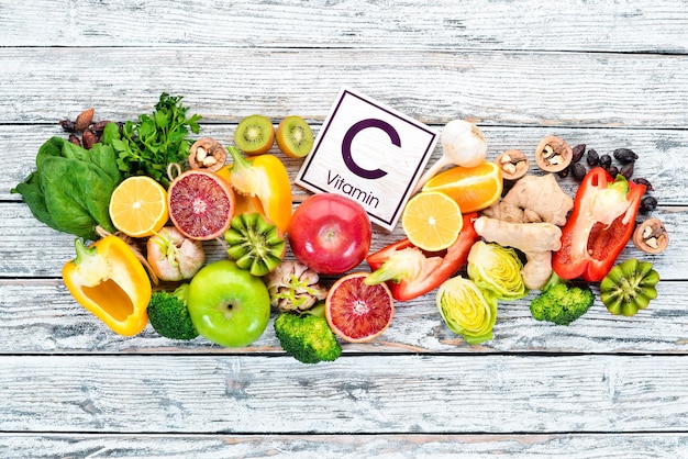 Voedsel dat natuurlijke vitamine C bevat Sinaasappel-citroen-appel-roos-knoflook-broccoli-appel-kiwi-spinazie Bovenaanzicht Op een witte achtergrond