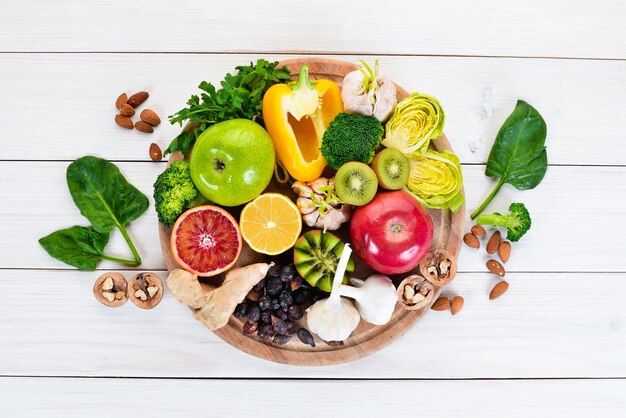 Voedsel dat natuurlijke vitamine C bevat Sinaasappel-citroen-appel-roos-knoflook-broccoli-appel-kiwi-spinazie Bovenaanzicht Op een witte achtergrond