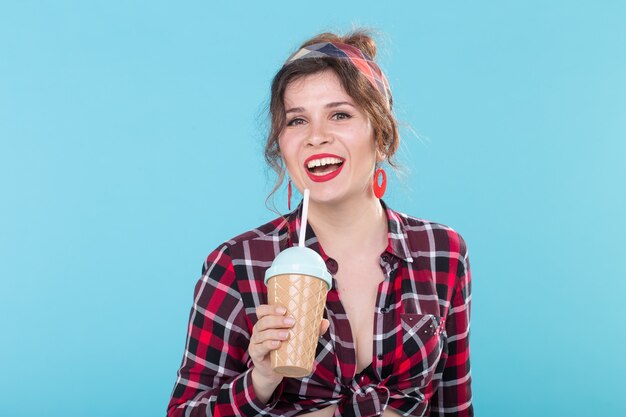 Voedsel, dieet en leuk concept - vrouw in pin-up stijl met een glas koffie.