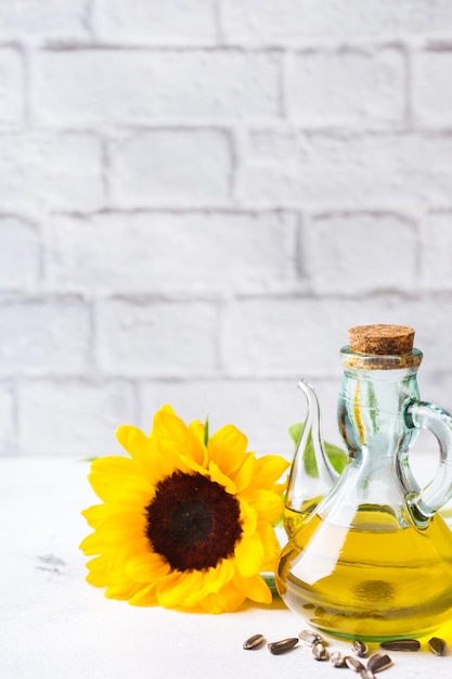 Voedsel dieet en voeding concept assortiment van verse biologische extra vierge zonnebloemolie in flessen met bloemen op een witte keukentafel kopieer ruimte achtergrond