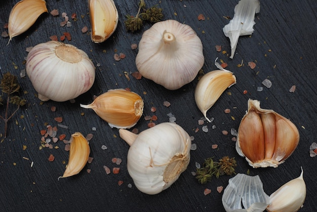 Voedsel Fotografie. Eten bereiden. Knoflook met kruiden op zwarte achtergrond. Zout en peper.