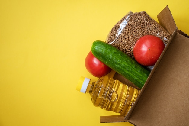 Voedsel in een kartonnen doos op een gele achtergrond