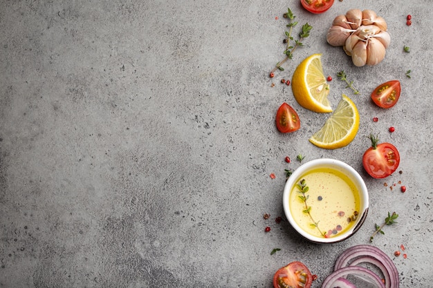 Voedsel koken achtergrond op grijze stenen rustieke tafel met verse ingrediënten, groenten, kruiden, specerijen, olijfolie van bovenaf met ruimte voor tekst