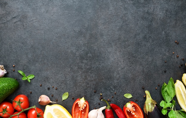 Voedsel koken achtergrond op zwarte tafel. verse groenten, specerijen, kruiden. ingrediënten om te koken