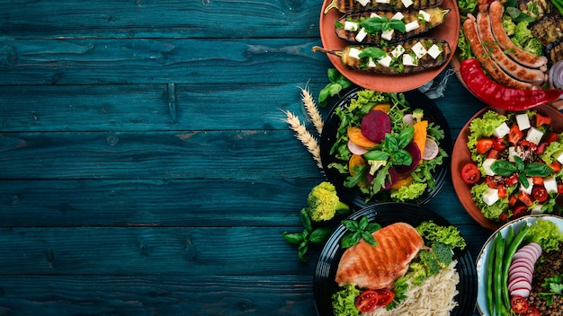 Voedsel Linzen Havermout Kip Tomaten Worstjes Aubergine Gezonde voeding Op een blauwe houten tafel Bovenaanzicht Vrije ruimte voor tekst