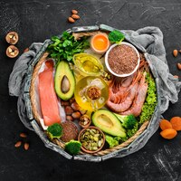 Voedsel met natuurlijke vitamine omega 3 gezonde voeding vis garnalen broccoli vlas noten ei peterselie bovenaanzicht vrije ruimte voor uw tekst op een zwarte achtergrond