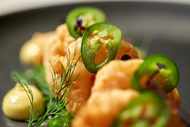 voedsel, nieuwe Noordelijke keuken, culinaire en kookconcept - close-up van koningsgarnalen met jalapeno op bord