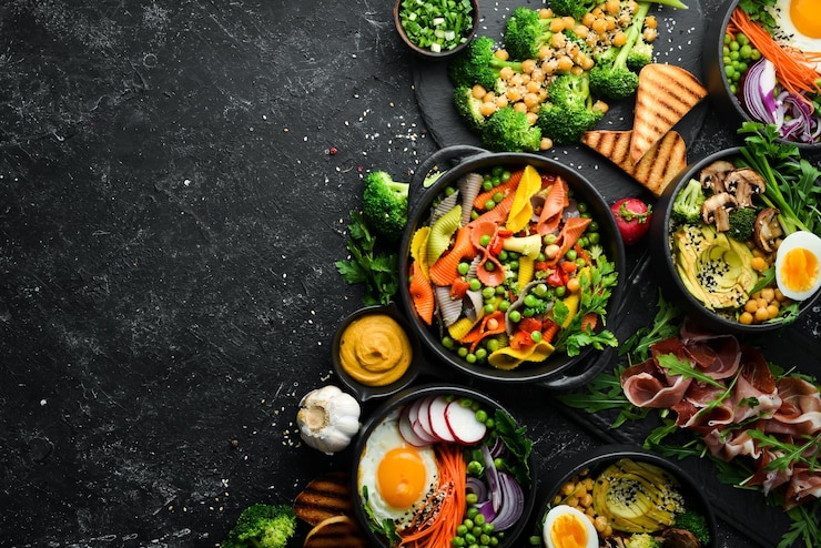 Foto voedsel pasta varkensribbetjes avocado boeddha kom en bietensalade op een zwarte stenen achtergrond bovenaanzicht vrije ruimte voor tekst