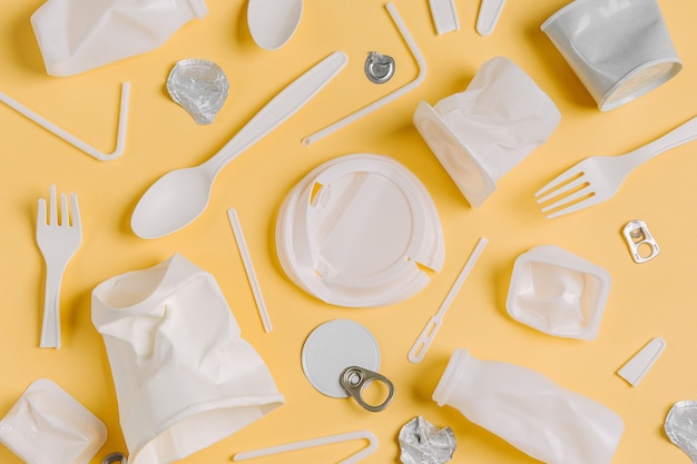 Voedsel plastic verpakkingen op gele achtergrond. Concept van recycling van plastic en ecologie. Platliggend, bovenaanzicht