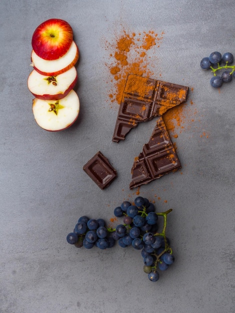 Voedsel tegen kanker goed voor het cardiovasculaire systeem verse rijpe druif en pure chocolade op een betonnen achtergrond Voedsel rijk aan resveratrol-antioxidanten