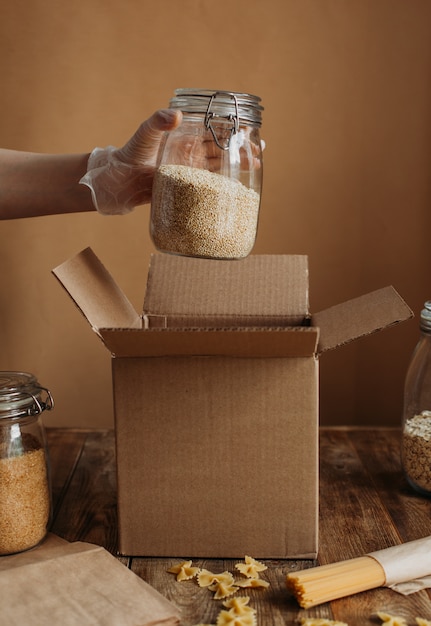 Voedsel wordt verzameld in een donatiedoos op een houten tafel.