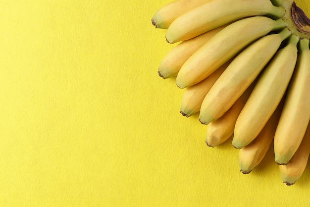 Voedselachtergrond met banaanfruit op geel document.