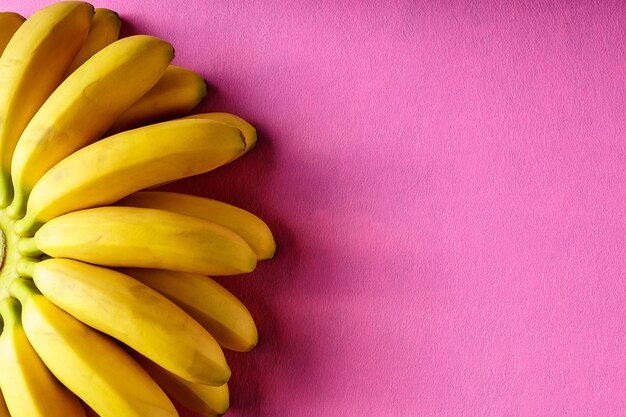 Voedselachtergrond met banaanfruit op roze document.