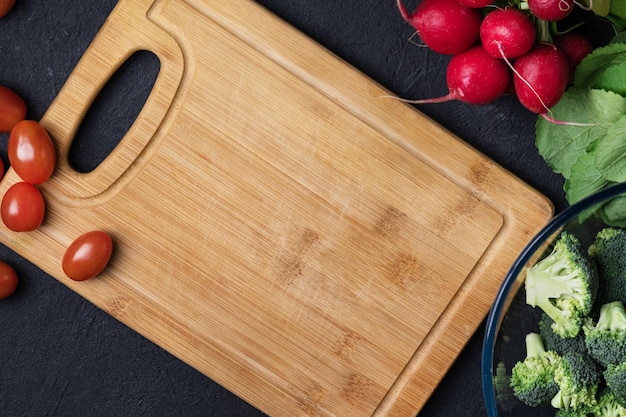 Voedselachtergrond met snijplank en groenten bovenaanzicht Ingrediënten voor de bereiding van veganistische gerechten