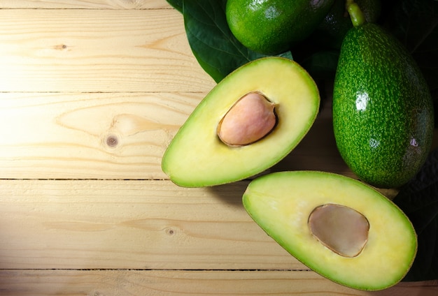 Voedselachtergrond met verse organische avocado op oude houten lijst,