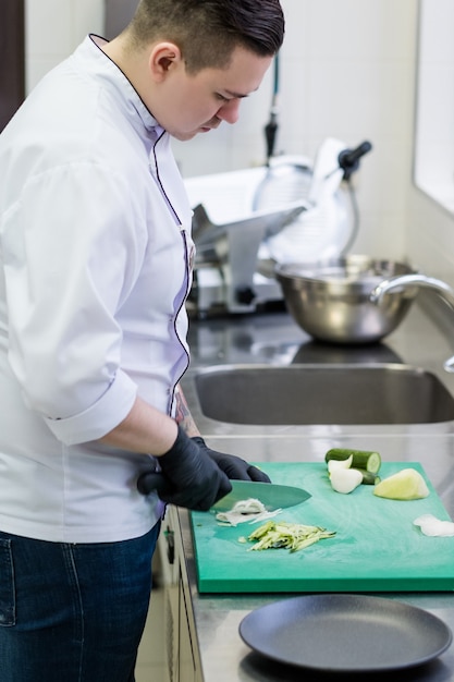 Voedselbereidingsproces in de keuken van het restaurant. Voedselingrediënten hakken voor een maaltijd