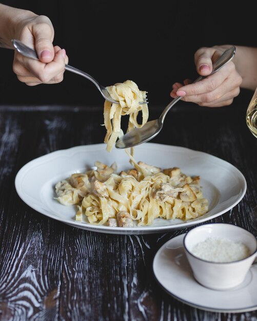 Voedselfotografie Italiaanse pasta Meisjeshanden met een vork en lepel close-up