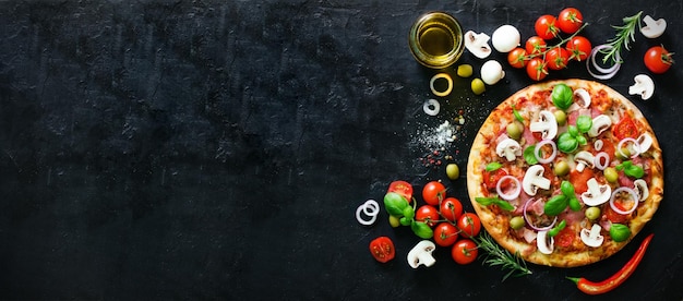 Voedselingrediënten en kruiden voor het koken van champignons, tomaten, kaas, ui, olie, peper, zout, basilicum, olijven en heerlijke Italiaanse pizza op zwarte betonnen achtergrond Copyspace Bovenaanzicht Banner